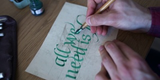 年轻人用绿墨水在纸上练习书法