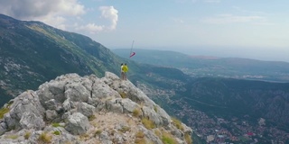 一对游客站在山顶俯瞰科托尔古城，黑山。空中无人机视图。生活方式和旅游理念。