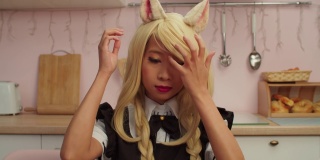 可爱的亚洲女人在狐狸cosplay服装在室内涂红色唇膏