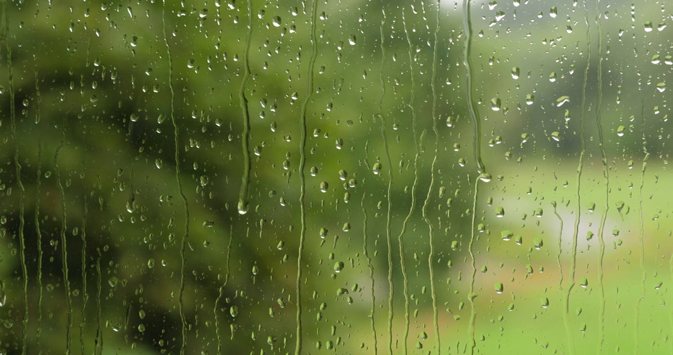 小雨打在玻璃上。夏天的雨雨滴沿着窗户落下。外面雨窗口。淋浴坏天气。平静放松的冥想宁静的背景。雨天，秋天，忧郁，悲伤，孤独