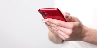 一个女人手里拿着红色的智能手机，背景是白色的