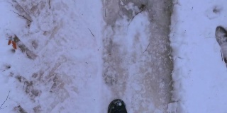 游客在冰雪和厚厚的积雪上徒步旅行的照片。边走边看前面。