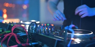 跟踪拍摄的男子DJ玩混音和数字转盘。带有电线、按钮和滑块的CDJ唱盘，由夜总会的电子音乐主持人播放。