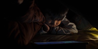 一个小男孩在晚上学习使用药片