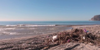 土耳其阿兰亚市一场强风暴过后，海滩被树木碎片和塑料垃圾污染。海滩上的垃圾。环境污染