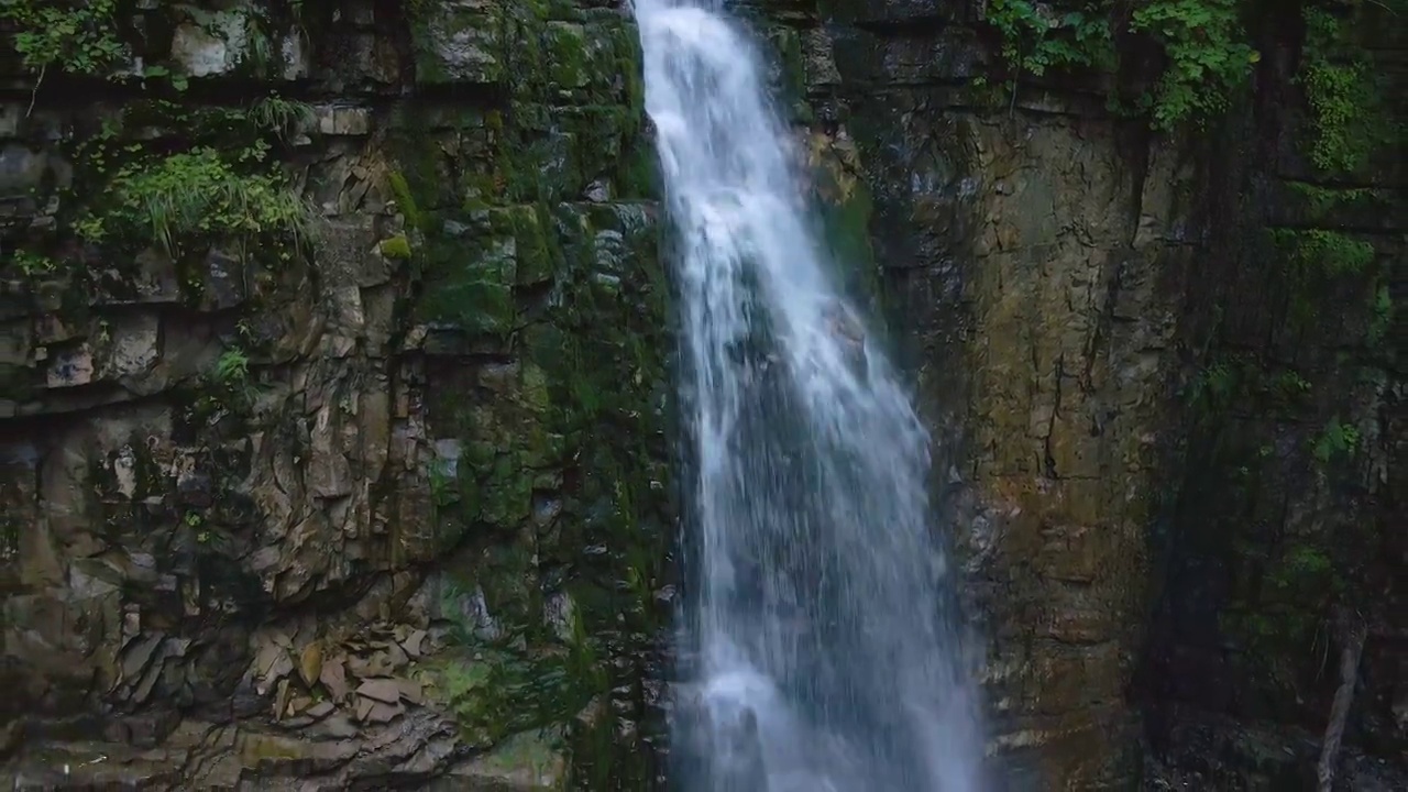 在夏天的热带雨林中，美丽的山河瀑布和白色的泡沫水从岩石悬崖上落下