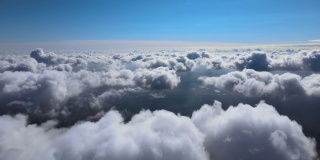 从飞机窗口高空俯瞰，在暴雨前形成的蓬松的积云覆盖着大地