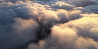 高空鸟瞰图，远处的城市被傍晚暴雨前形成的蓬松的积云所覆盖。飞机角度多云的景观