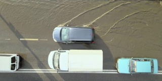 城市交通鸟瞰图，汽车行驶在暴雨后被淹没的街道上。道路排水系统的问题