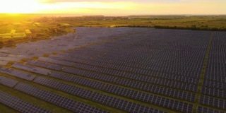 鸟瞰图，大型可持续发电厂，在日落时，一排排太阳能光伏板用于生产清洁的生态电能。零排放的可再生电力