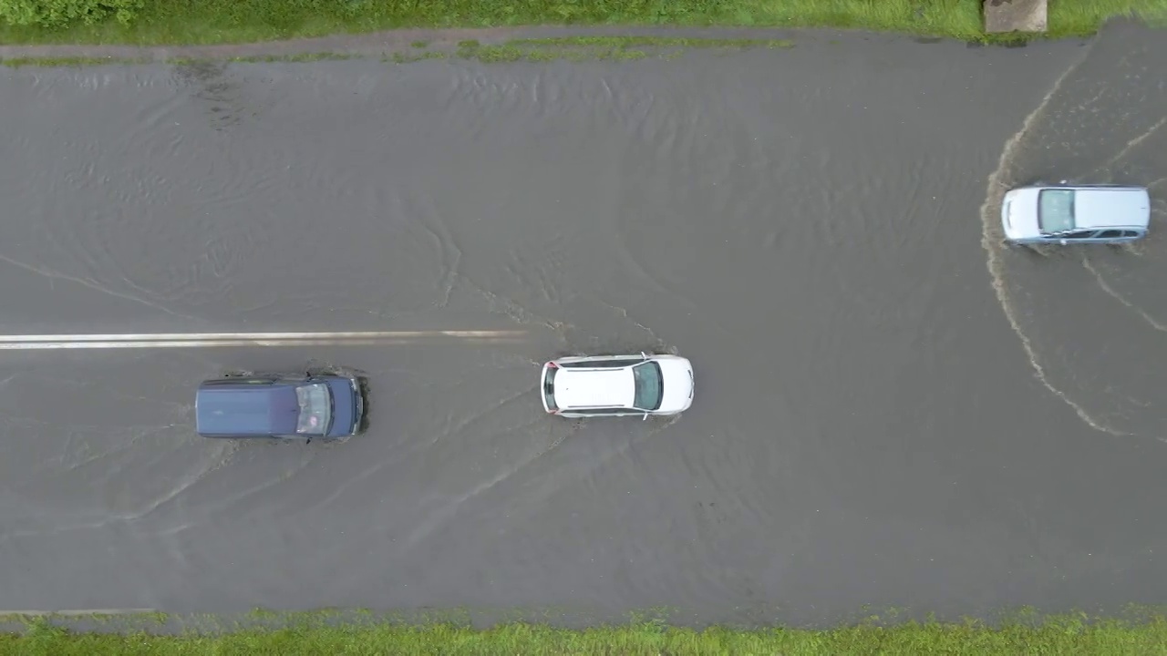 城市交通鸟瞰图，汽车行驶在暴雨后被淹没的街道上。道路排水系统的问题