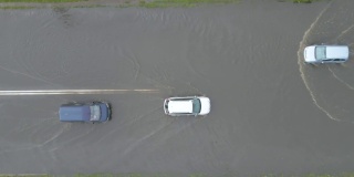 城市交通鸟瞰图，汽车行驶在暴雨后被淹没的街道上。道路排水系统的问题