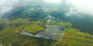 在阴天没有阳光的情况下，大型可持续发电厂的鸟瞰图，上面有许多排太阳能光伏板，用于生产清洁的生态电能