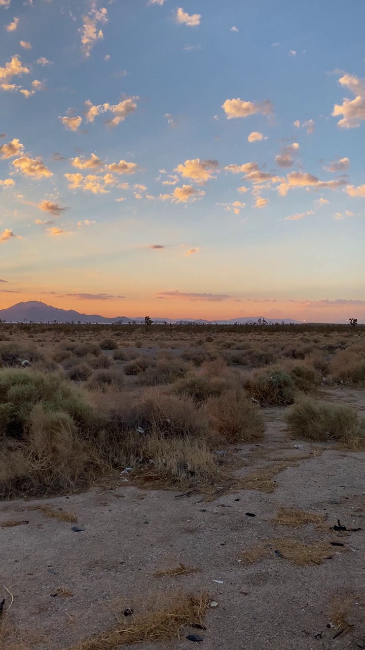 美丽的日出沙漠山脉地平线平移运动与太阳flair云和蓝色橙色天空垂直视频