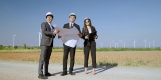 检查员和一名工程师以及一名秘书正在检查一个风力发电机发电领域的项目。清洁能源理念，可再生能源，拯救世界。