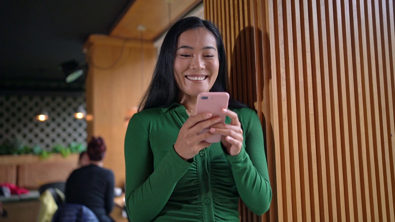 在候机室等待下机的时候，亚裔现代女性使用手机