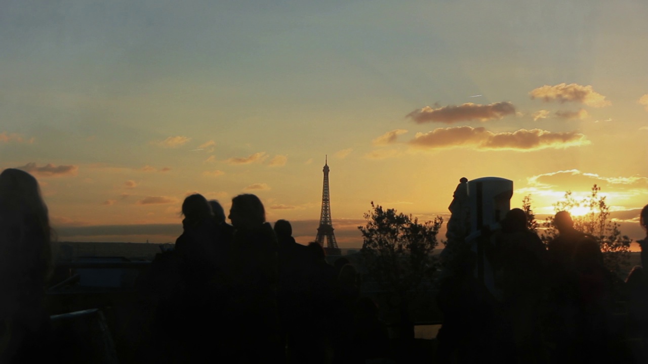 法国巴黎，人们在老佛爷画廊的屋顶欣赏日落。