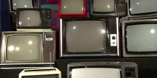 堆叠式复古电视机打开绿色屏幕。多莉，4K分辨率。