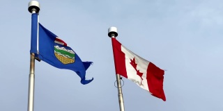 在一个刮风的日子里，飘扬的阿尔伯塔省国旗和加拿大国旗