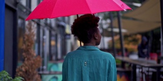 后视图的年轻女子黑人种族站在伞下