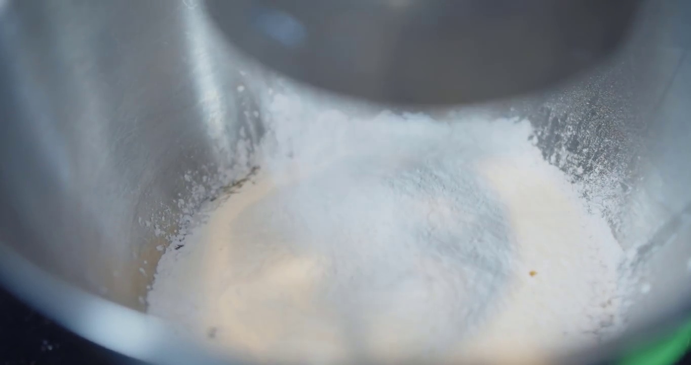 慢动作近距离的面粉通过筛子磨碎掉入碗中，配料和准备阶段为烹饪烘焙烘焙蛋糕在厨房，面粉类似雪