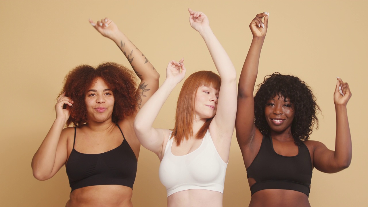 混合种族的妇女用慢动作举起双手跳舞