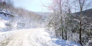 阳光明媚的骑在雪乡路上，开车经过雪山公路