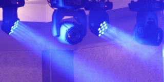 光束是由安装在舞台上的反射器产生的，男男女女在舞台上跳舞