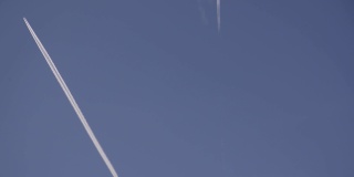 两架喷气式飞机在蓝天上飞行，身后留下白色的条纹