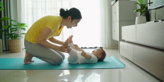 亚洲年轻妈妈抱着孩子的脚玩耍