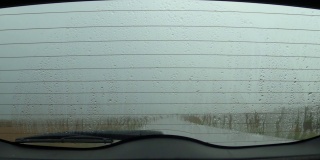 在雨中行驶，透过汽车后挡风玻璃观看