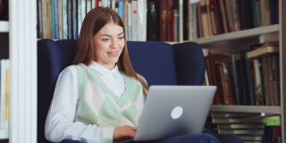 一名女子在图书馆用笔记本电脑上网聊天