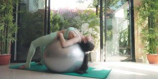 年轻的亚洲妇女在家里玩瑜伽的健康或健康的生活方式的概念。