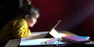 学龄前女孩在光束下使用数码平板电脑的4K视频