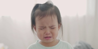 一个在家里哭的亚洲小女孩