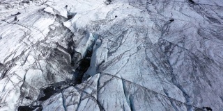冰岛索尔海马冰川鸟瞰图。冰缝和黑色的火山灰。全球变暖和气候变化的概念