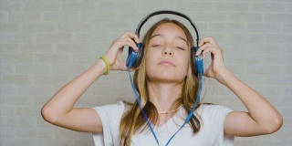 十几岁的女孩戴着耳机，听着硬摇滚音乐
