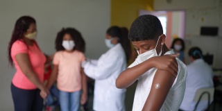 一个男孩在接种疫苗后展示他的手臂的肖像