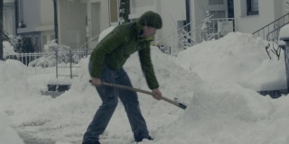 男子在雪天铲雪