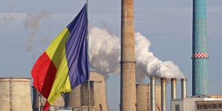 罗马尼亚国旗迎风飘扬，背景是罗马尼亚南部布加勒斯特热电厂。罗马尼亚的污染概念。