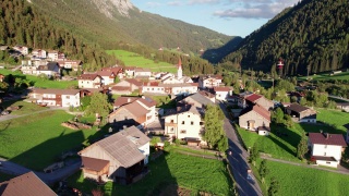 鸟瞰图，一个奥地利村庄在绿色的山谷在日落，阿尔卑斯山视频素材模板下载