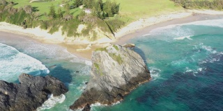 澳大利亚新南威尔士州Narooma海滩上的温室岩石的无人机特写镜头