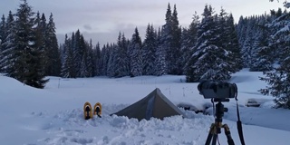 冬天的雪山上露营和拍视频。一个徒步旅行者的观点。