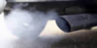 慢动作和散焦燃烧烟雾从汽车排气管烟雾