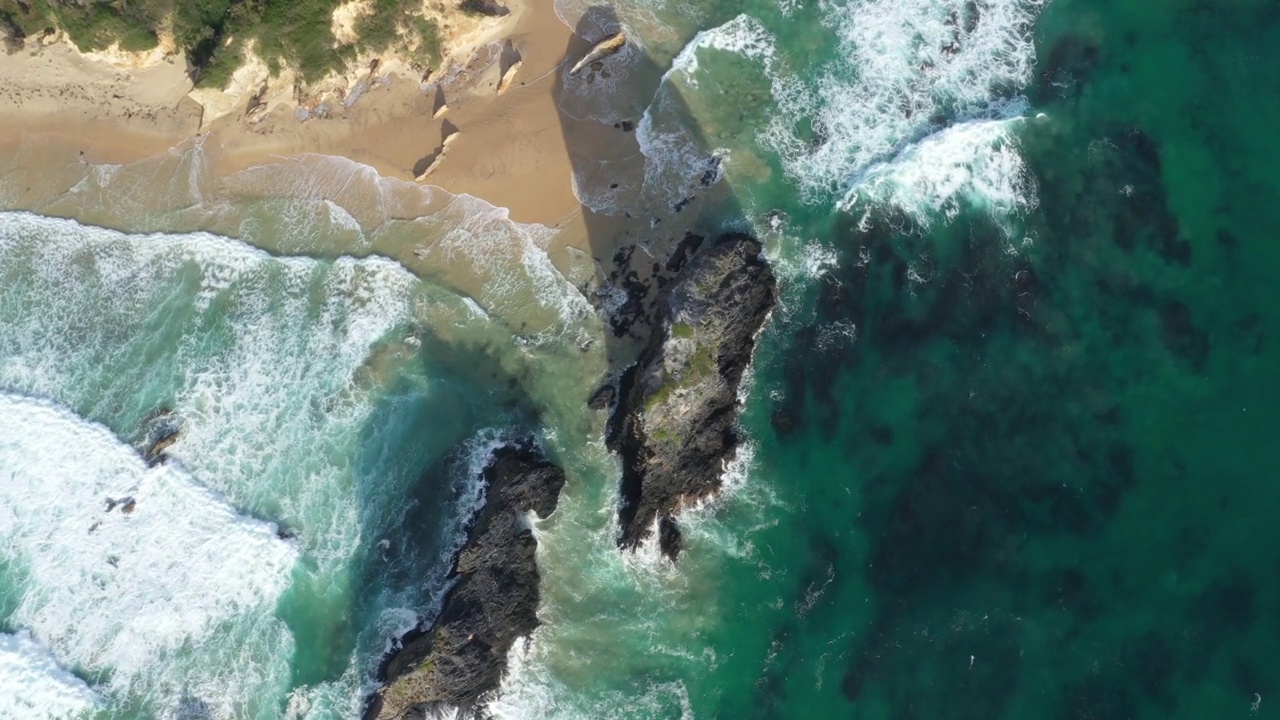 澳大利亚新南威尔士州Narooma海滩上的Glasshouse Rocks上的无人机照片