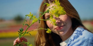 美丽的女人的脸与春园外的油菜花枝叶交相辉映。