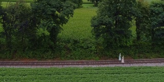 鸟瞰图，两个阿米什女孩走在阿米什农场的单轨轨道上
