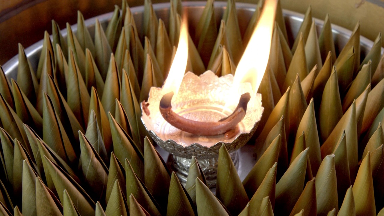 特写-手放点燃的香薰蜡烛，为金字塔或香蕉叶形的泰国甜点添加香味，为中国新年。节日的传统食物和甜点。