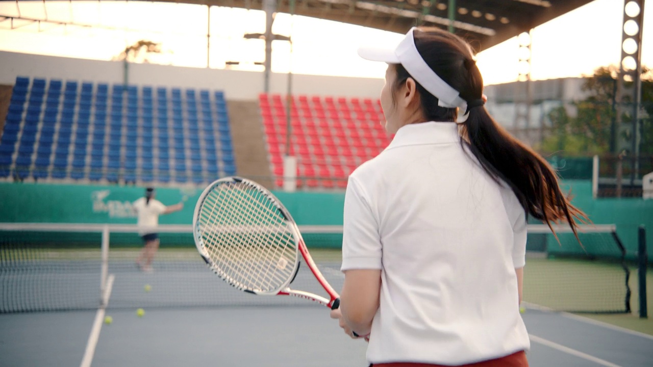 在网球场打双打比赛的资深网球运动员。