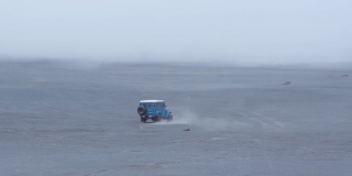 一辆旅游吉普车行驶在布罗莫山的沙漠上